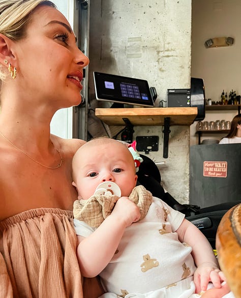 Photo of a woman at a restaurant dining table laughing and entertaining her baby in his stroller beside her; photo of woman sitting at restaurant dining table carrying her baby boy in her lap as he faces the camera; photo of woman carrying her friend's baby boy in her lap and smiling sitting at a restaurant dining table