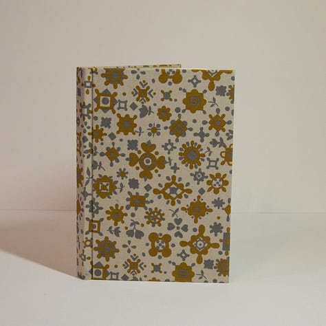 three different hand bound hard cover books.