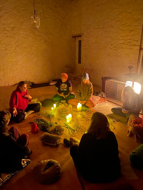 L-R: a white house with blue accents at sunset with lawn in front, three white women crouching with their back to camera, slighting candles, with a mandala or flowers behind them, a Black woman's hands crafting a cardboard loom for weaving, 6 white women in a barn sitting in a circle around dried flowers and candles with a roaring fire to the right, 11 women standing in a circle on a lawn, women sitting in a semi-circle around a mandala of flowers, with taped circles on the floor and post-it notes