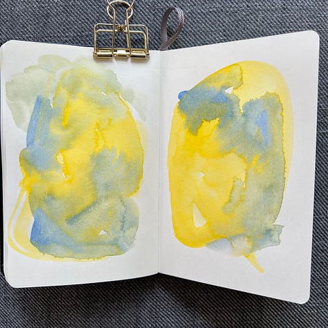 Different pages in a small sketchbook painted with light washes of watercolor in a variety colors