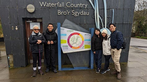 people smiling at the waterfalls of the brecon beacons