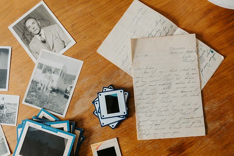 old letters, photographs and slides on a wooden table