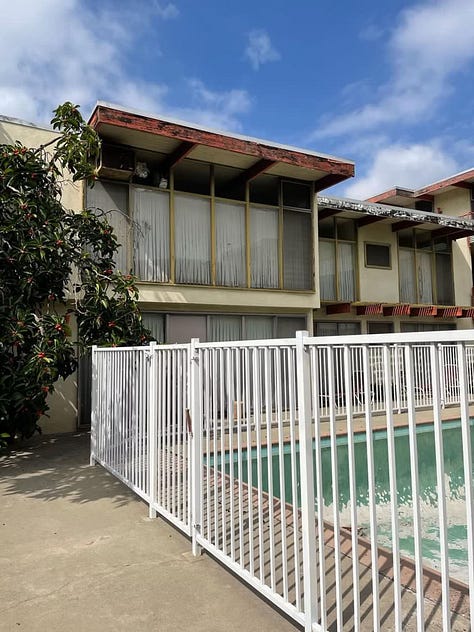 2040 Rodney Avenue, a midcentury modern apartment complex that has been empty for years and is suffering from deferred maintenance (mold, stucco damage, peeling paint, a long-empty pool, cracked concrete, rust stains, etc.).