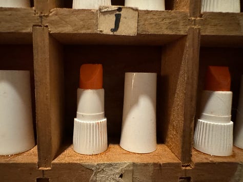 Image of lipstick samples in a wooden wall box. A black-and-white of Step at the pool.