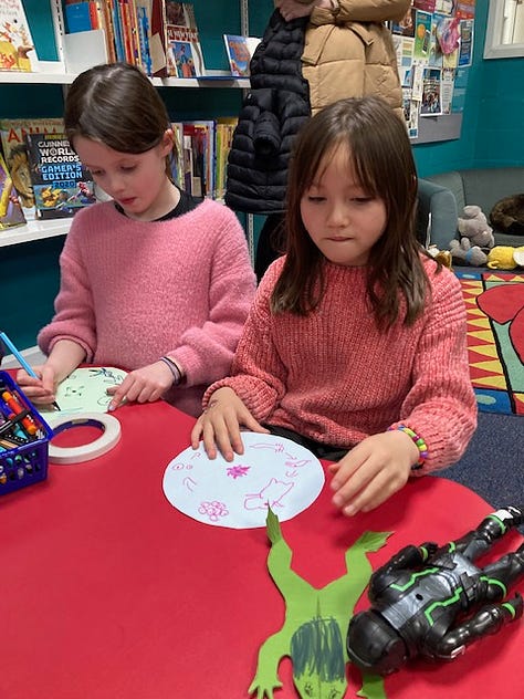 Children getting hands on in Ullapool LIbrary with Ranger Jenny