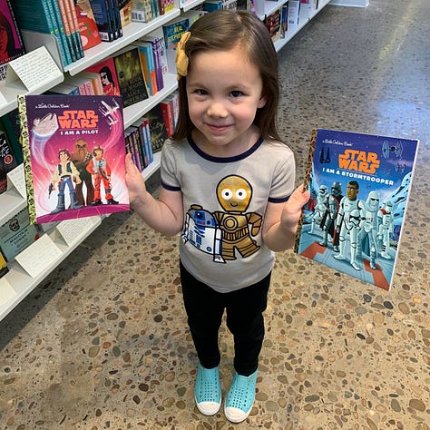 My daughter, Hannah, enjoying Star Wars Golden books, and Darth Vader Legos