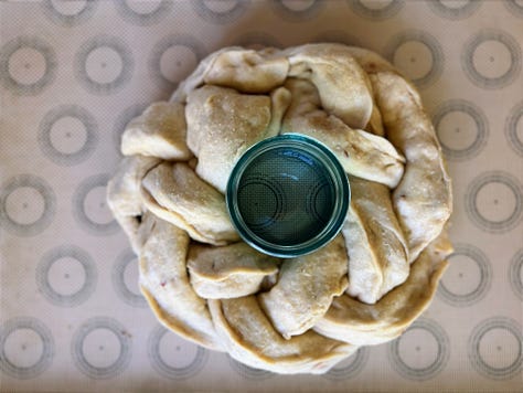 Pictures show process of stuffing challah dough with apples and weaving it into a crown around a jar that is then filled with honney.