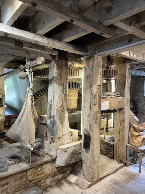 10 photographs showing the inside of Town Mill, Lyme Regis. The milling is done on two floors. On the upper floor the grain is poured into the hopper from where it falls by vibration and gavity down to the millstones below. The grain is then ground and falls into the waiting bag. Flour is sold at the mill and one photo shows bags of flour in plain brown paper bags. Images: Roland's Travels