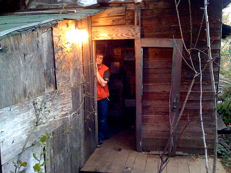 L to R: Back door to Bob's cabin, Toby and Bob. Bob was in hospice care and got to die at home, in his cabin, as he wished; Bob's cabin, which he built with Rosa, in the early 70s. He first bicycled to Big Sur in 1952, from the Bay Area. For love, of course; Bob "in state," in nature. Toby found some lupin and rosemary to wrap in his sheets; Susie wearing Bob's vest, in the cabin; Jay takes a look out at Partington Ridge with Bob; "Saint Bob." He would laugh at this one. He had little use for religion; Jon's drawing of Bob, in his bed, before we moved him outside. He wanted to be cremated, and since he lived so far from the road, we "wrapped" him in his bed linens, and carried him, like pallbearers without a coffin, up to the road where a fellow from the Mortuary met us; and Sula, Bob's executor, also drew Bob as he was in bed. This looks more like Bob when he was alive... he was a big, strong, guy!