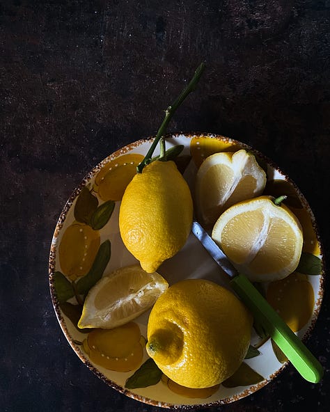 Three still lifes with lemons, whole and quartered, sunlit in southern France