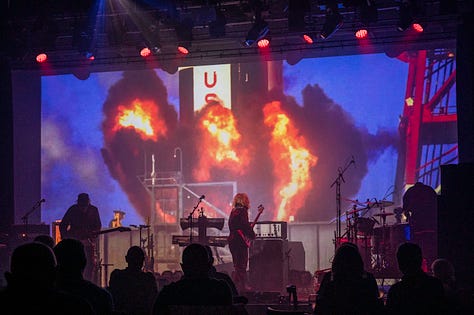 Starlite & Campbell - musicians on stage playing guitar, bass , drums with different backdrops