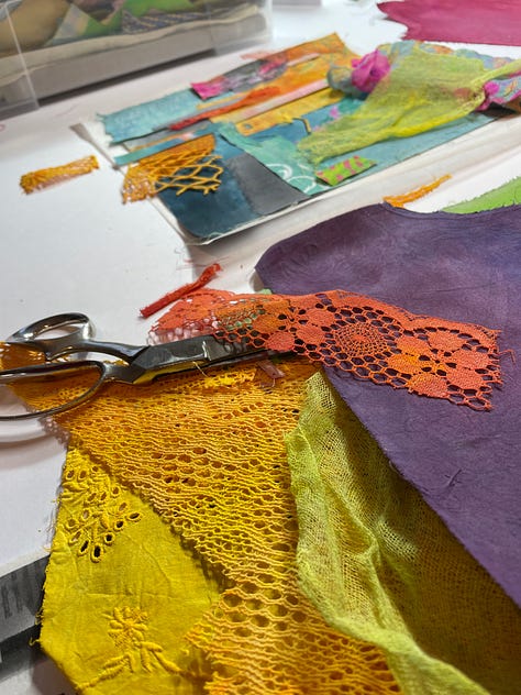 colourful fabric  and fabric scraps with bundles of threads on top