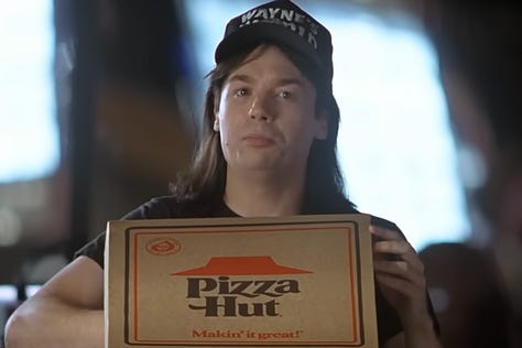 Mike Meyers with a box of Pizza Hut Pizza in the Product Placement scene in Wayne’s World (1992) with Rob Lowe | Film Flavor: A Newsletter Surveying Food in Film