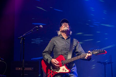 Starlite & Campbell - musicians on stage playing guitar, bass , drums with different backdrops