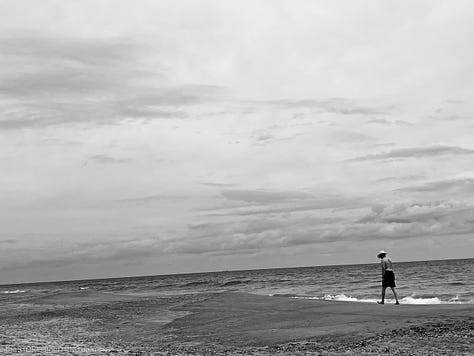 Man in hat walking along the Atlantic OCean beach