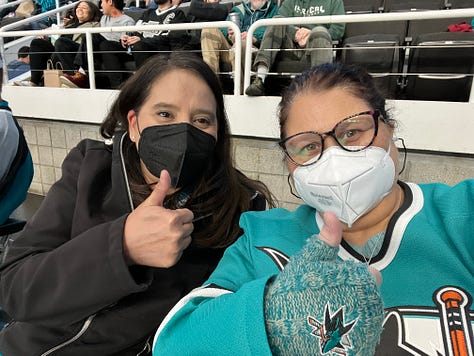 images of hockey arena, 2 girls wearing masks, a mascot shark on ice