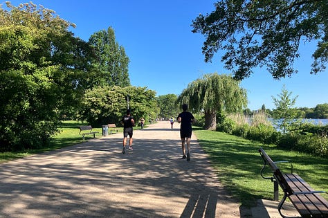 Runners on wide beige gritty paths under a blue sky