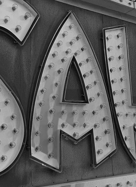 Three vintage neon letters that spell "a-ha"