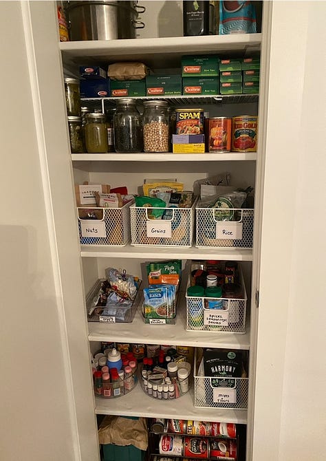 Large pantry with magnet spice wrack on the open door and storage containers on the shelves.