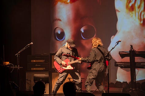 Starlite & Campbell - musicians on stage playing guitar, bass , drums with different backdrops