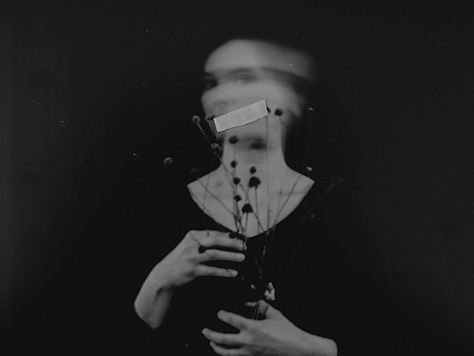 Portrait of a person in a torn up image holding dried flowers, with tape over her eyes, and with tape over her mouth. 