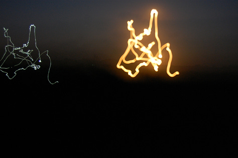 Close up of cobbled streets, pineapple smashed into street, swirly light streak, falling ice sign, i feel happy today note, we'd love to see you naked sign, light from fire juggler, guitar stencil on wall, paving stone street