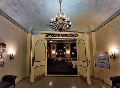 A collage of photos showing the Historic Hotel Bethlehem, including two photos of the 9-story brick exterior, and interior pictures of the elevators, white marble staircase with polished handrail, open doors to the ballroom with a glistening chandelier, and two photos of the lobby, with luxurious black leather furniture in front of a huge arched window with a Christmas wreath in the middle. Also a look inside a room of a bed with a robe lying on the end.