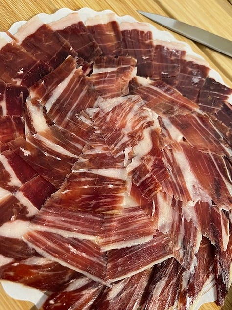 Three pictures of food including a chocolate cake, three chocolate truffles wrapped in green foil, and a plate of sliced meat charcuterie.