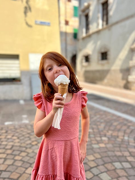 Picture of a girl eating an ice cream on a cone (gelato in Italy), identical twins eating gelato on a cone, and a girl dipping a spoon into a glass cup of yogurt with jam and berries.