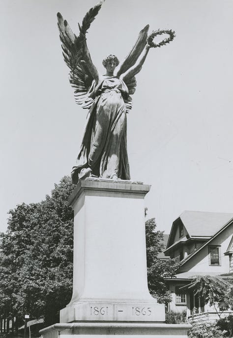 Images show the Soldiers' and Sailors' Monument at its original location in the middle of Hillside Avenue at what is now Merrick Blvd.