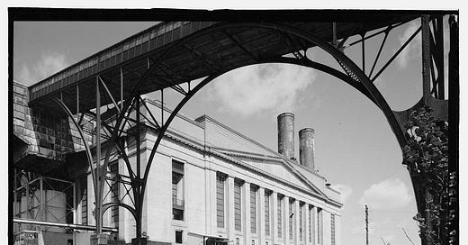dramatic comparison photograph showing abandoned rust belt factory with broken windows beside modern glass office building