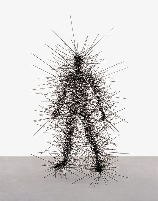 A human figure made out of hundreds of straight steel rods that jut out and criss cross to create a person's form where they overlap.