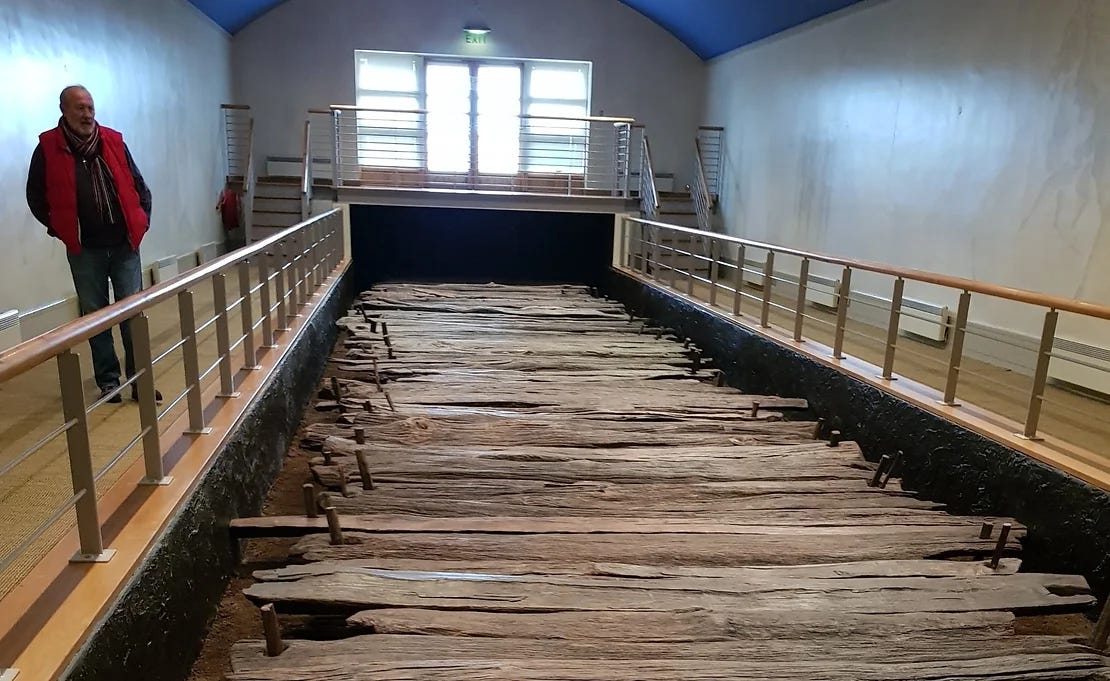 The rough-hewn chunky planks of the Corlea trackway, preserved within a building with a viewing platform on all sides