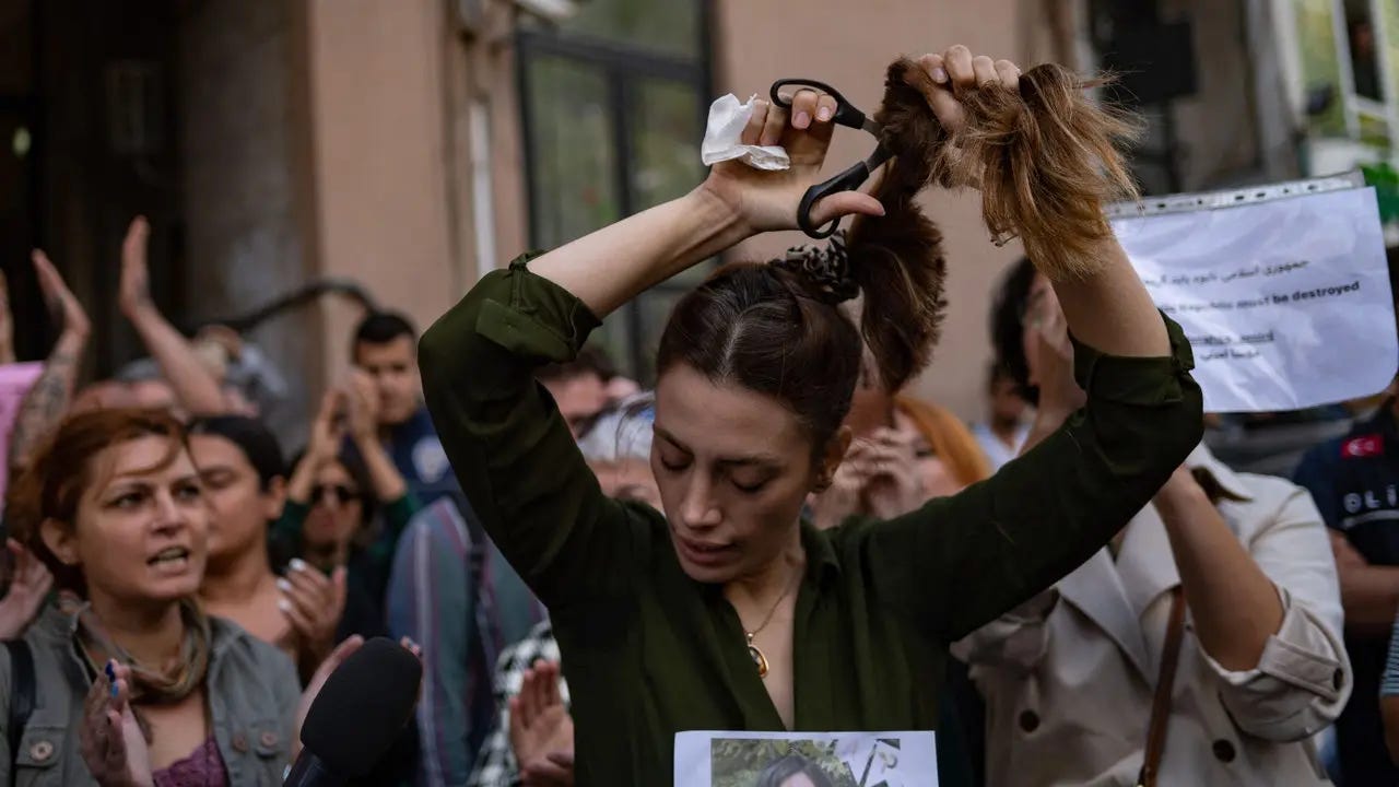 An Iranian woman cuts off her hair to protest the death of Mahsa Amini