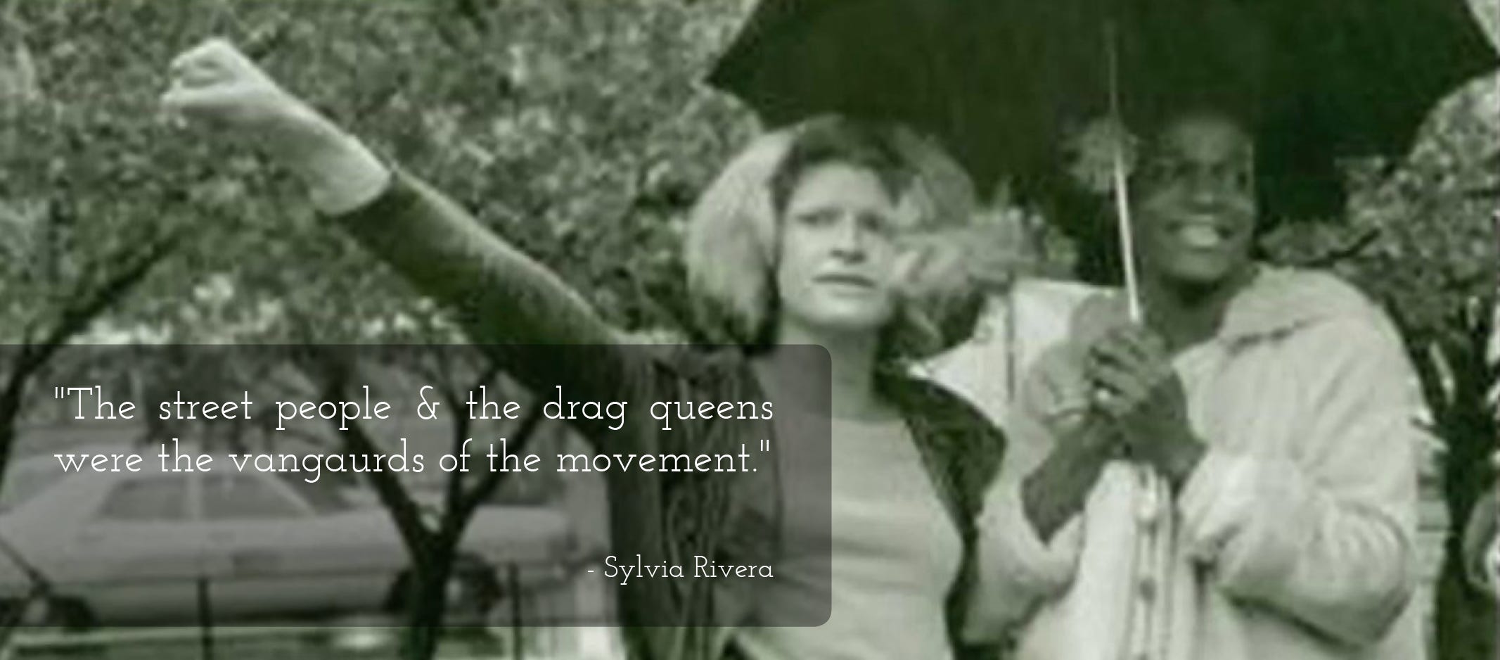 Black & white photograph showing Sylvia Rivera (fist raised in the air) on the left and Marsha P. Johnson (holding an umbrella) on the right. Quote from Sylvia Rivera to the left of the image reads: “The street people & the drag queens were the vanguards of the movement”