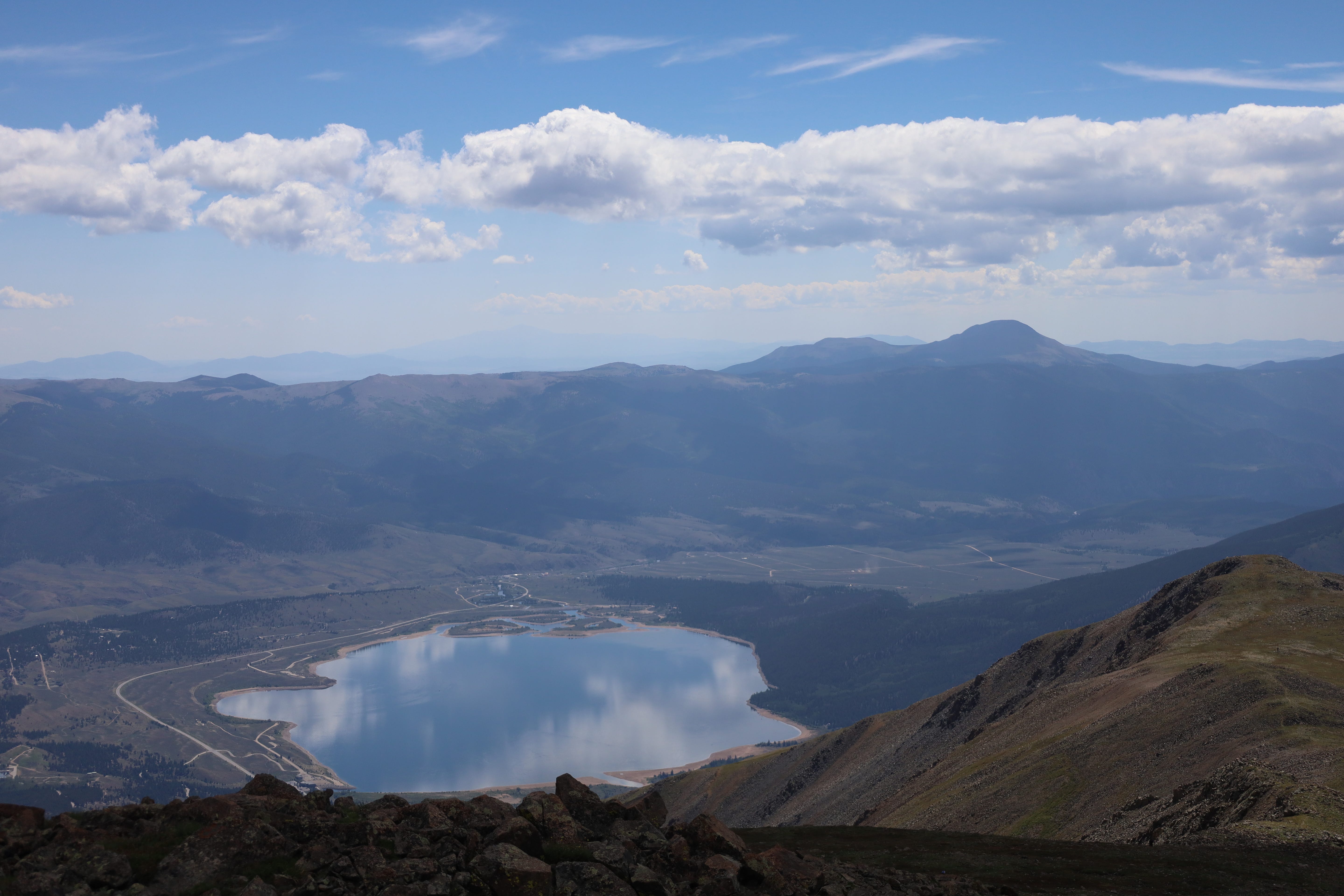 a reflective lake seen from the top of Elbert