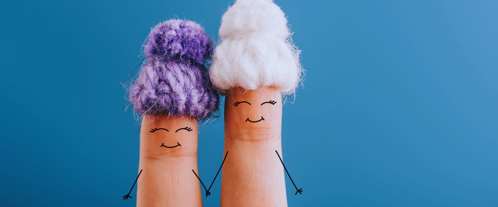 image of two fingers with smiling faces wearing knit hats