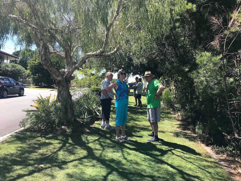 group of people standing in the shade on a Brisbane footpath