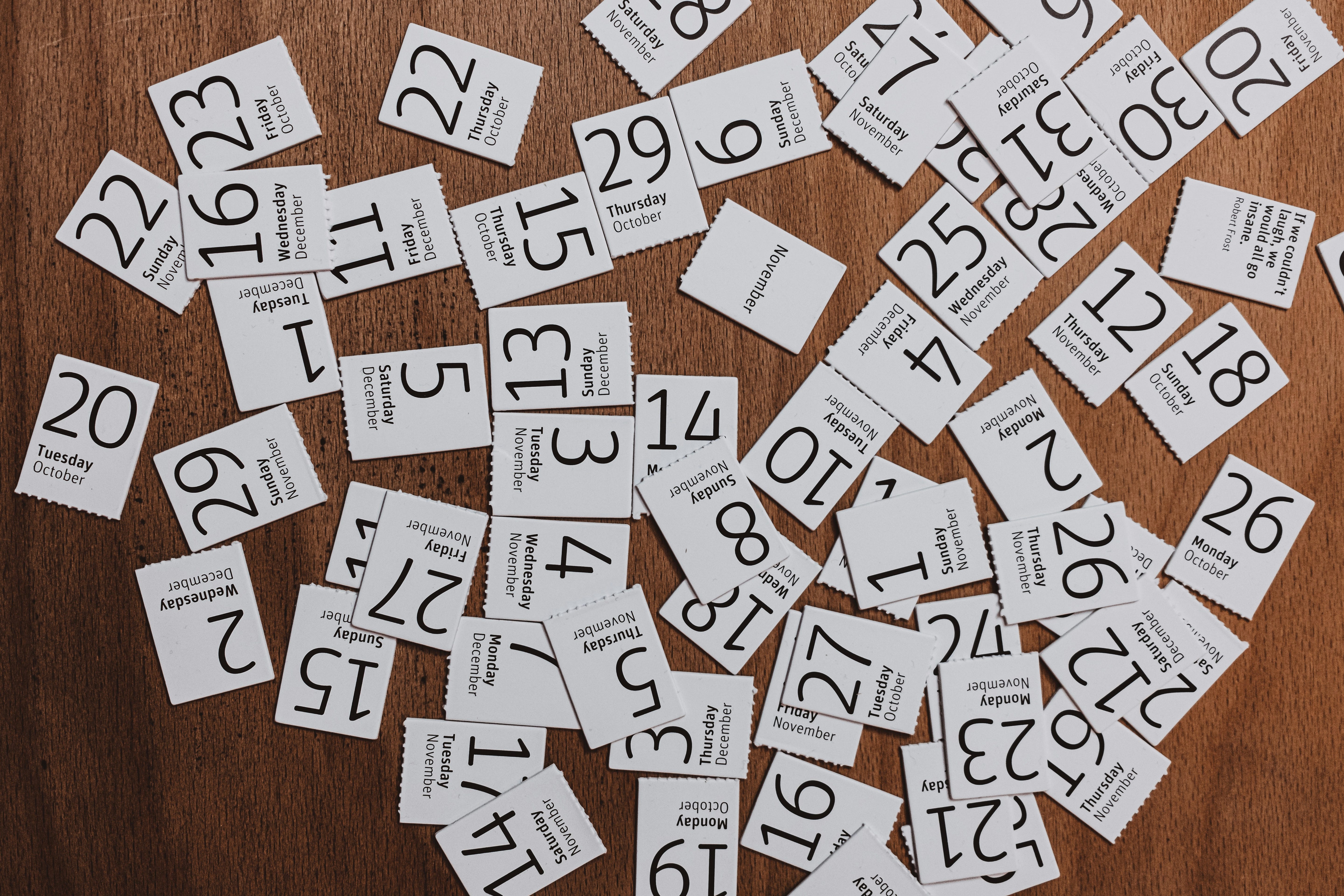 Dates of a calendar torn off and scattered on a desk