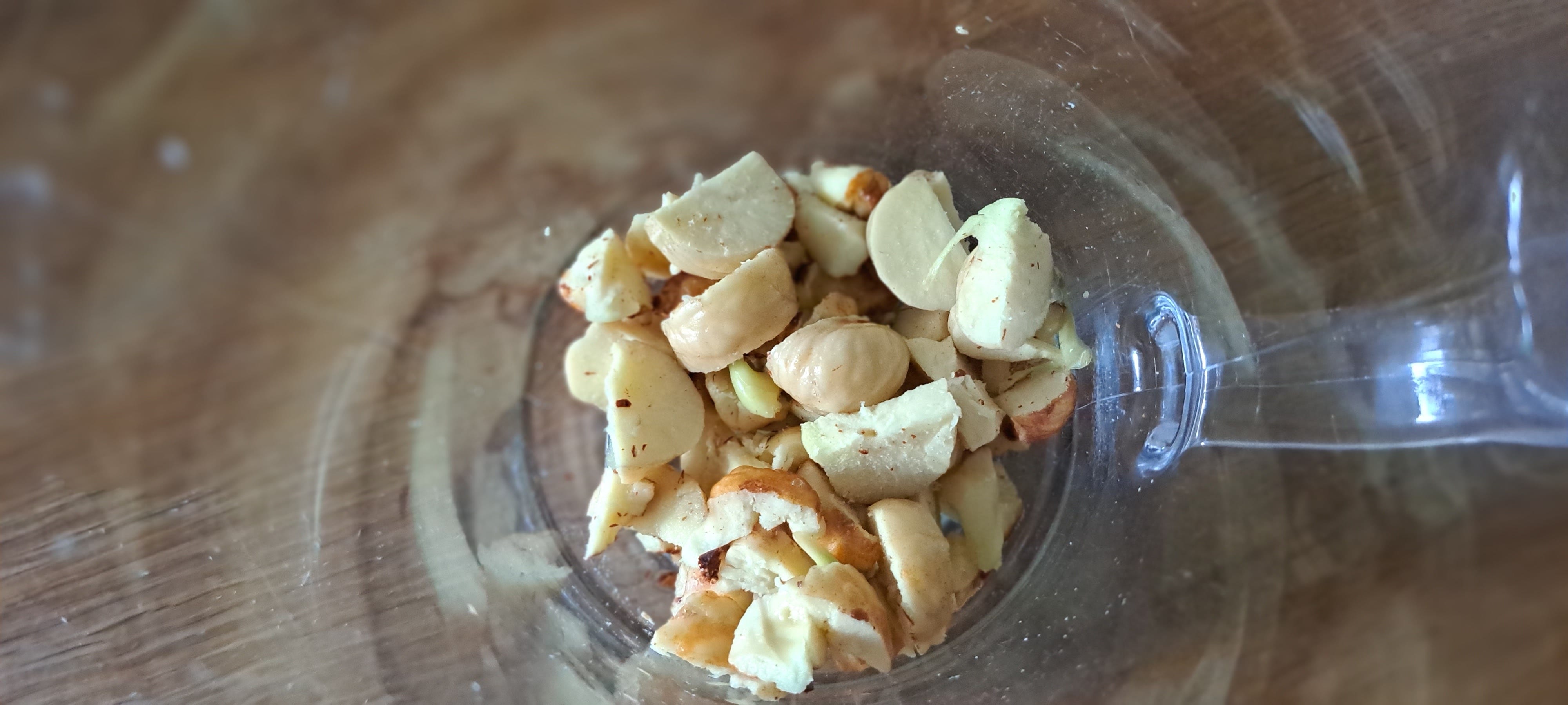 Image looking inside a glass jug at the chopped up creamy-white conkers.