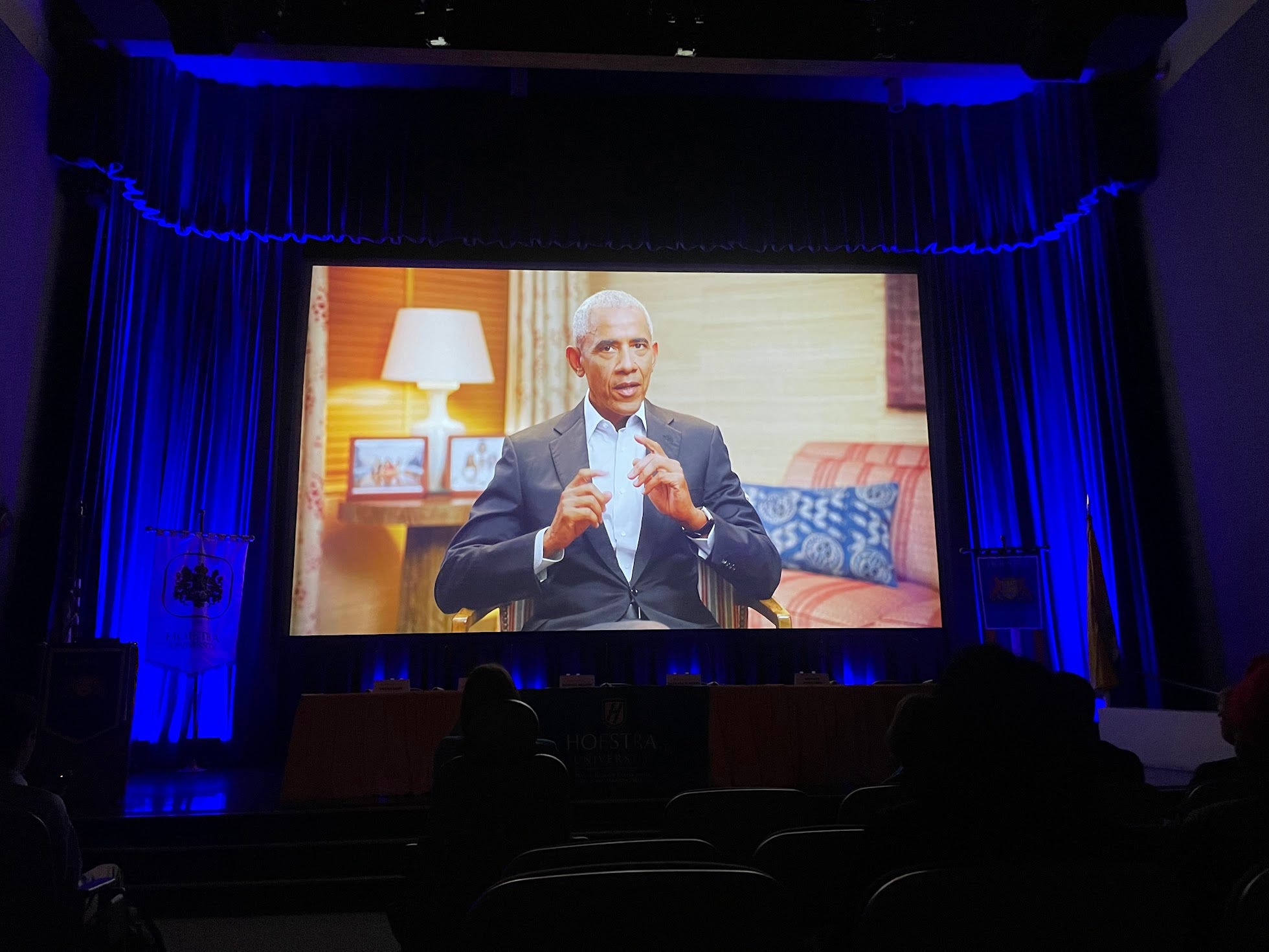Former President Obama shown on a large projection during the opening session of Hofstra University's presidential conference