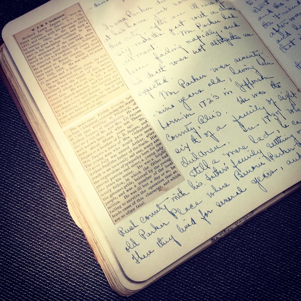 A handmade scrapbook from the early 20th century with newspaperclippings, photograph and handwriting.