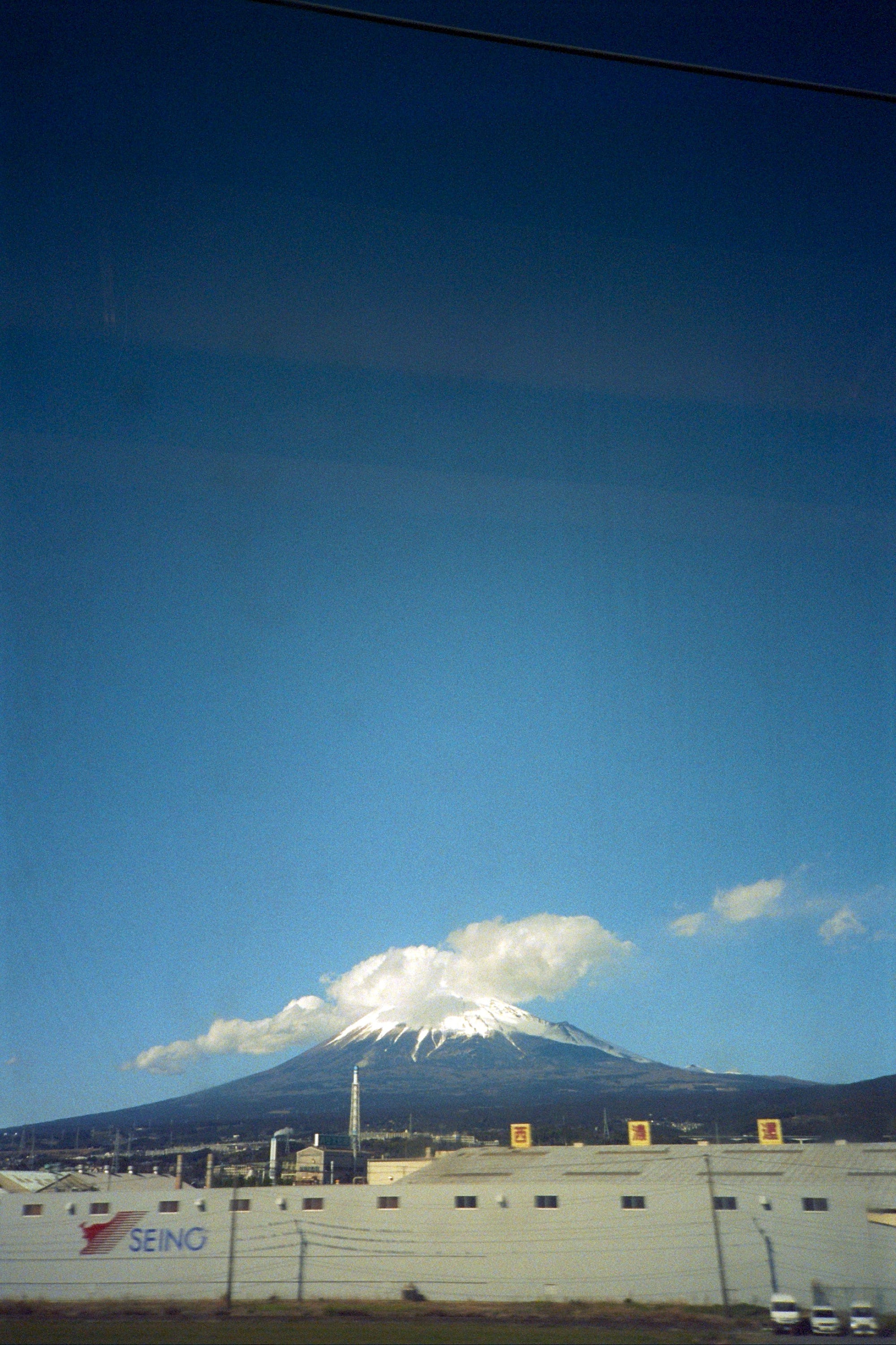 Mount Fuji (I think?) seen from a shinkansen high-speed train window.