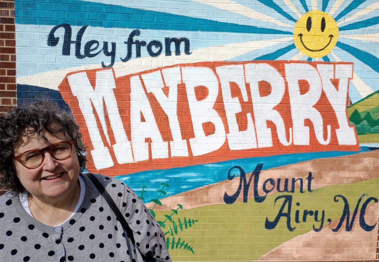 Annette with mural of postcard from Mayberry also known as Mount Airy North Carolina