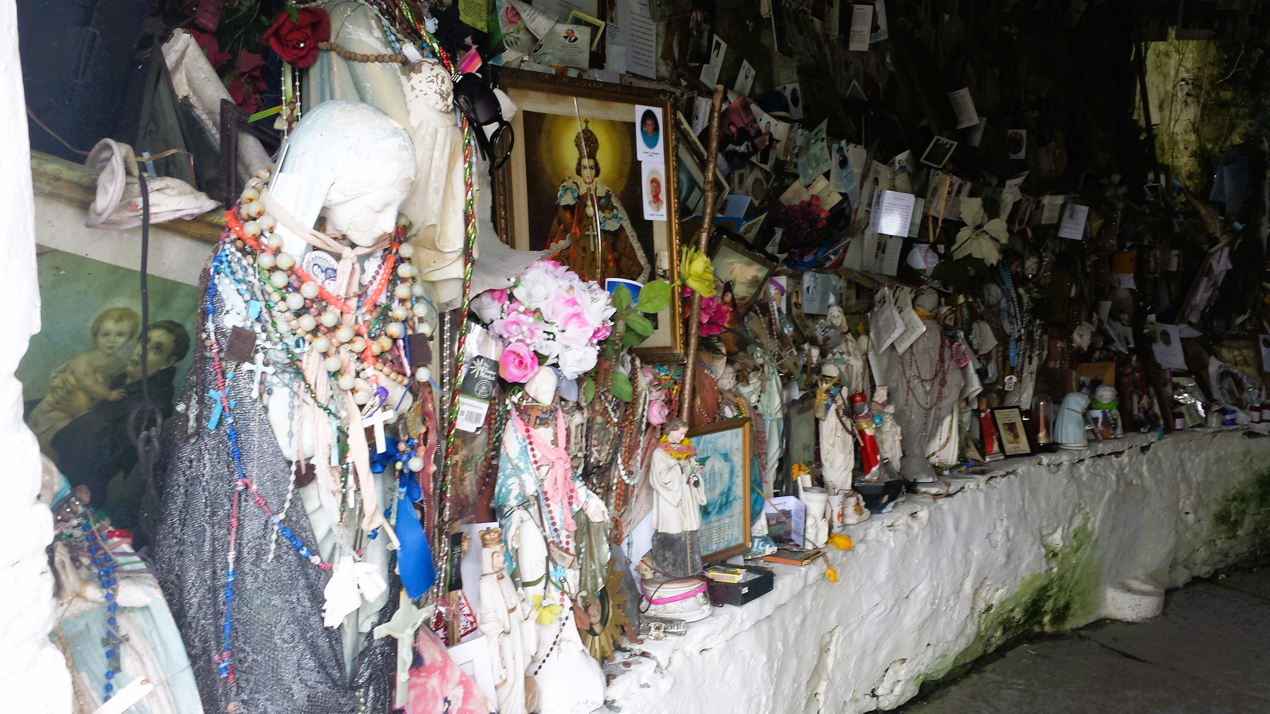 inside the extroardinary holy well of Maire na Gael, Brigid's holy well in County Clare, where people have left uncountable numbers of prayers, tokens, gifts and pictures for Brigid.