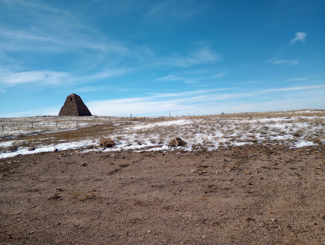 Pyramid on treeless plain with light snow on ground