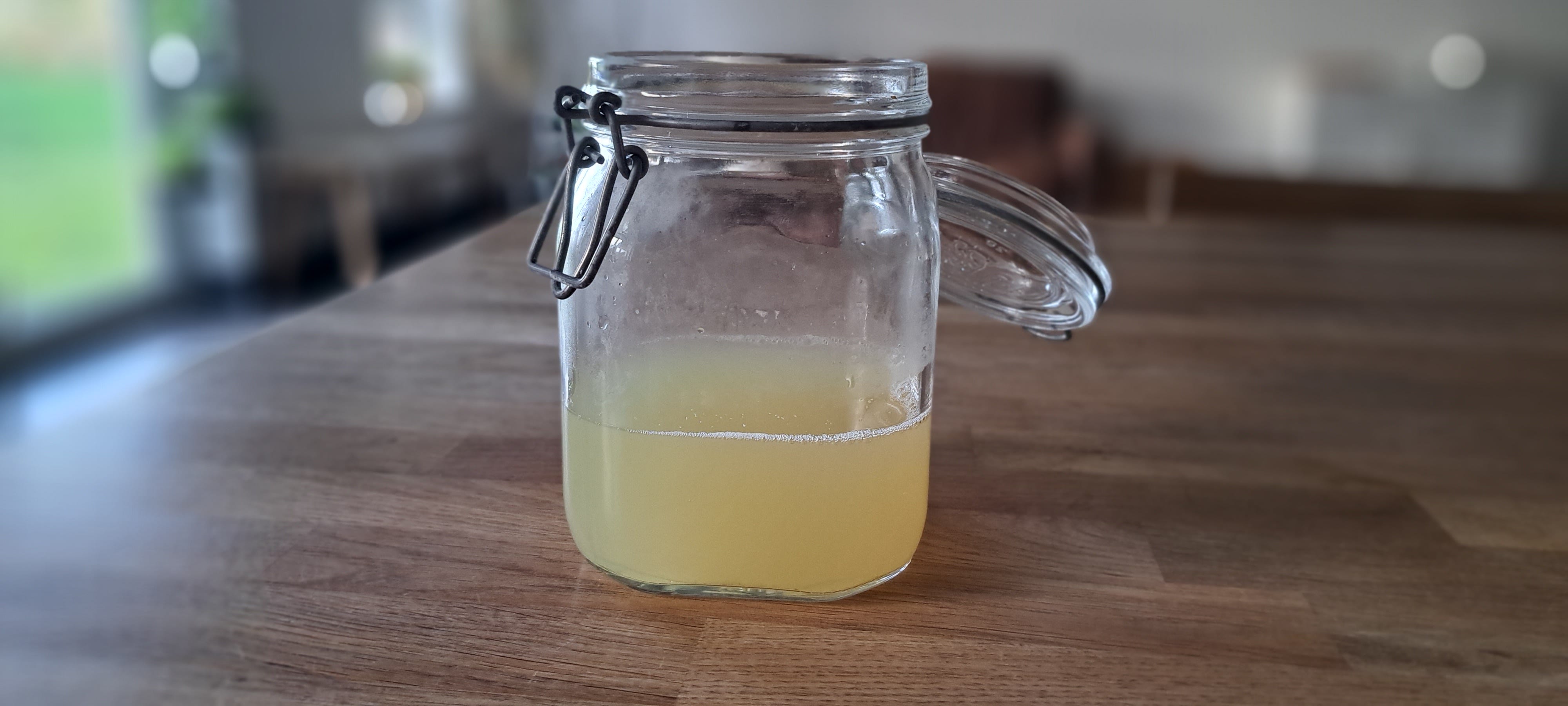 A glass jar half-filled with a yellowish looking liquid sits on my work-top; this is the finished laundry detergent.