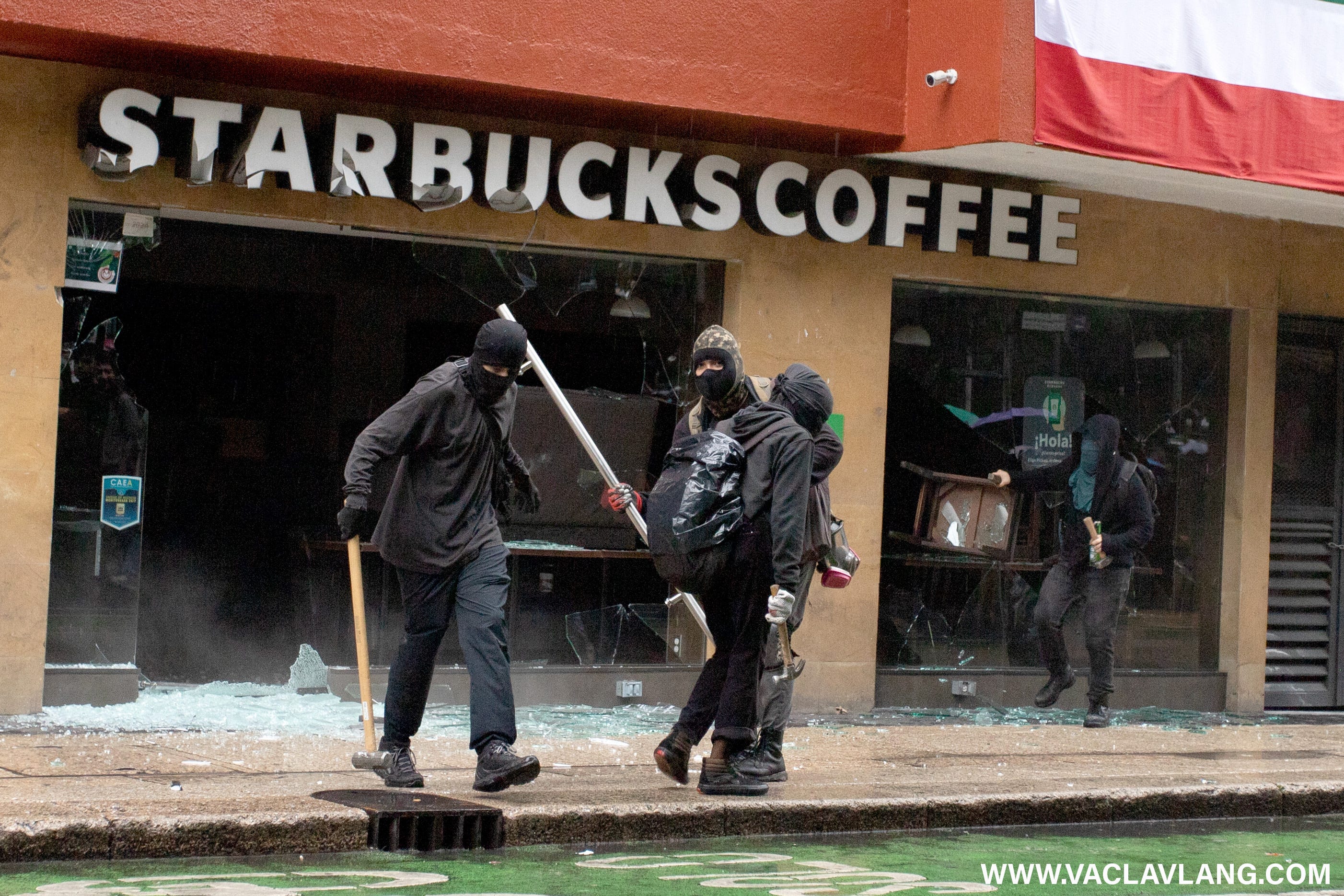 Demonstrators smashing the windows of Starbucks coffee shops.