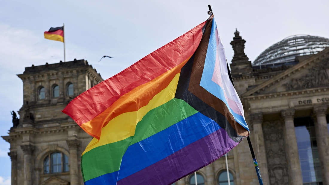 Eine Regenbogenflagge vor dem Reichstag in Berlin