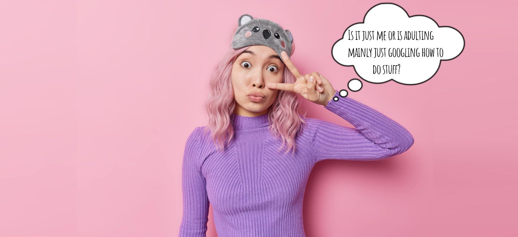 Young woman with pink hair making a silly face and a cartoon koala sleep mask on her head — throwing a peace sign